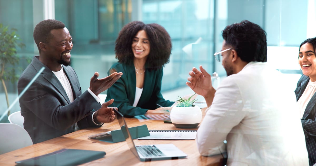 Colleagues reviewing program documents together around a table in a bright office